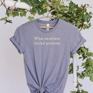 May include: Gray t-shirt with the text "What excellent boiled potatoes" printed in white.