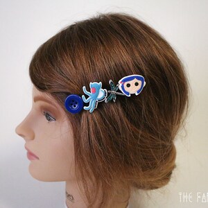 Puede incluir: Pinza para el pelo con un bot&oacute;n azul, un pulpo azul, una lib&eacute;lula y una ni&ntilde;a de dibujos animados. El accesorio para el cabello est&aacute; sujeto a cabello casta&ntilde;o. Un accesorio para el cabello &uacute;nico.