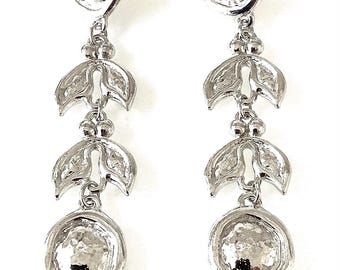 May include: Silver dangle earrings with a hammered round disc and three leaf-shaped charms.