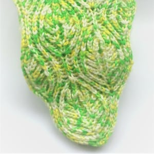 May include: A green, white and yellow knitted scarf with a textured pattern.