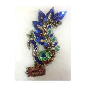 May include: A peacock design embroidered patch with blue, green, gold, and brown sequins and beads.