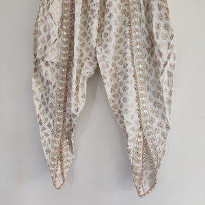 Cream dhoti pants for women. Tulip pants with gold print and beaded border.
