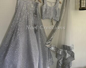 Silver Bling party wear lehenga skirt with stitched blouse and dupatta. Indian style wedding trousseau collection.