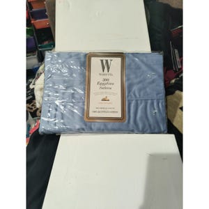 May include: A package of Wamsutta 300 thread count Egyptian Sateen flat sheet in a light blue color. The packaging includes a label with the brand name and product details. The sheet is made of 100% Egyptian cotton.