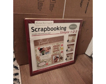 May include: A scrapbook kit with a red border, featuring the words "Paper Boutique Scrapbooking" and "Family." The kit includes everything needed for scrapbooking. The kit has photos of a family and decorative elements.