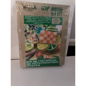May include: A Life of the Party Artisan Soap Making 101 Kit in a rectangular box. The packaging features images of various colorful handmade soaps, including checkered and citrus-slice designs. Text states it makes 10 soap bars, with a net weight of 2-16 oz.