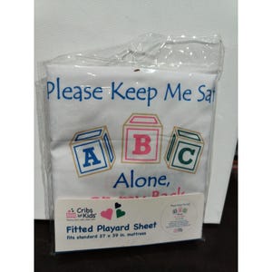 May include: White fitted playard sheet with the text "Please Keep Me Safe" and "ABC Alone". The sheet features three colorful block illustrations and fits a standard 27 x 39 inch mattress.