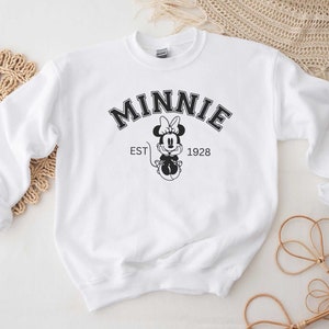 May include: White sweatshirt with a black and white graphic of Minnie Mouse and the text "MINNIE EST 1928".