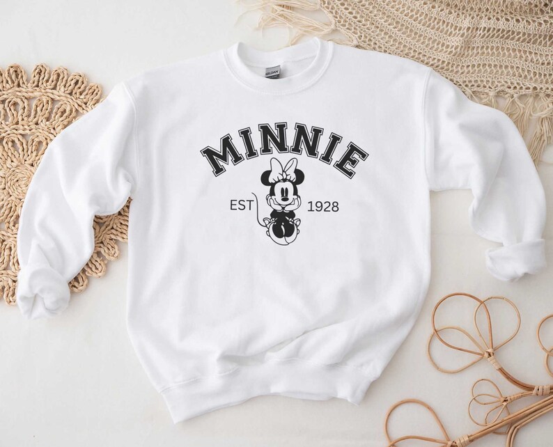 May include: White sweatshirt with a black and white graphic of Minnie Mouse and the text "MINNIE EST 1928".