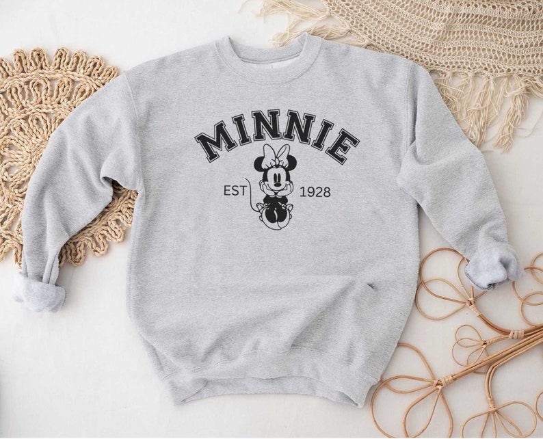 May include: Gray sweatshirt with a black and white graphic of Minnie Mouse and the text "MINNIE EST 1928".