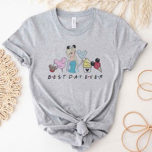 May include: Gray t-shirt with a graphic of a cartoon Disney princess holding a Mickey Mouse ice cream cone. The text "BEST DAY EVER" is printed below the graphic.
