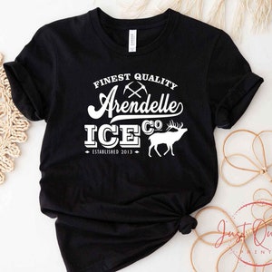 Puede incluir: Camiseta negra con texto blanco que dice "Finest Quality Arendelle Ice Co. Established 2013" con una silueta blanca de un reno.