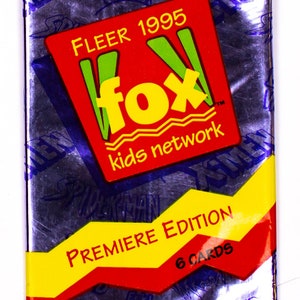 Puede incluir: Paquete de cartas coleccionables sellado con un fondo morado brillante. El paquete presenta un cuadrado rojo con "FLEER 1995" y "fox kids network" en amarillo y verde. Debajo, una pancarta amarilla y roja dice "PREMIERE EDITION 6 CARDS".