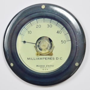 Könnte beinhalten: Rundes Milliamperemeter mit schwarzem Rand und cremefarbenem Zifferblatt. Die Anzeige reicht von 0 bis 50. Der Zeiger zeigt nach links. Der Text "MILLIAMPERES D.C." und "Western Electric MADE IN U.S.A. G2N" sind sichtbar.