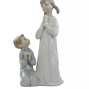 Figura LLADRÓ “Aprendiendo a orar”. Mide aproximadamente 22 cm de alto y 12 cm de ancho. Años 80.