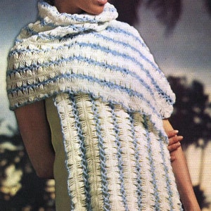 May include: A cream-colored crocheted shawl with horizontal blue stripes and a matching blue trim. The shawl is draped over the shoulders and features a textured stitch pattern, creating a cozy and stylish accessory.
