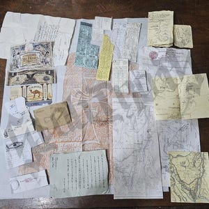 Peut inclure: Une collection de documents anciens, comprenant des cartes, des reçus, de la monnaie et des lettres manuscrites. Les articles sont disposés sur un tissu clair, avec une table en bois en arrière-plan. On peut voir un billet d'un dollar et un paquet de cigarettes Camel.