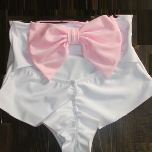 May include: White swimsuit bottoms with a large pink bow at the waist.