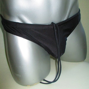 May include: Black swim briefs with a drawstring tie. The briefs are made of a smooth, silky fabric.