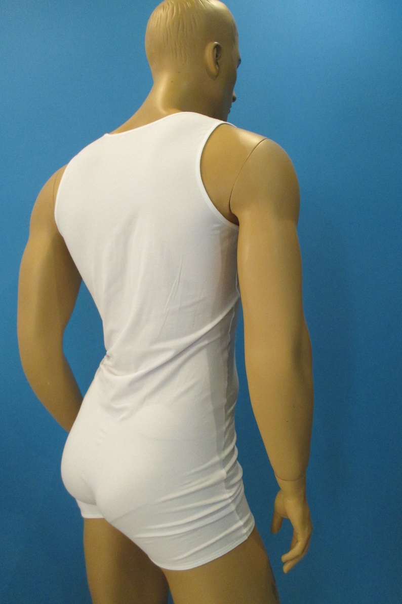 May include: White sleeveless undershirt with a scoop neck. The undershirt is made of a smooth, stretchy fabric.