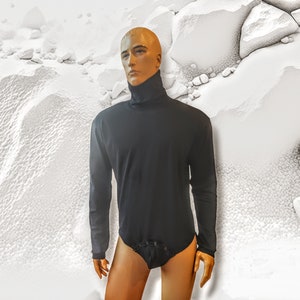 Könnte beinhalten: Ein schwarzes Langarm-Rollkragen-Shirt mit einem Stehkragen und langen Ärmeln. Das Shirt ist aus einem weichen, dehnbaren Stoff gefertigt und hat eine figurbetonte Silhouette.