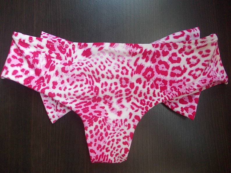 May include: Pink and white leopard print bikini bottom with a bow on each side.