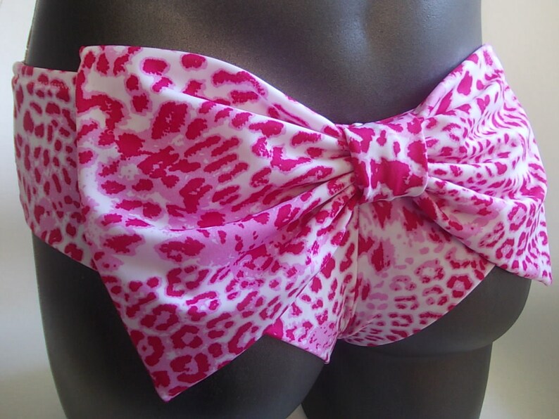 May include: Pink and white leopard print bikini bottom with a large bow in the back.