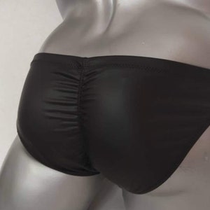 May include: Black leather-look swimming briefs with a gathered back detail.