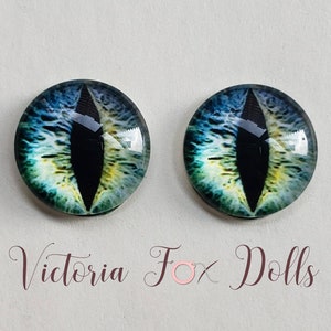 May include: Pair of blue, green, and yellow cat eye glass eyes with black pupils. The eyes are round and have a glossy finish.