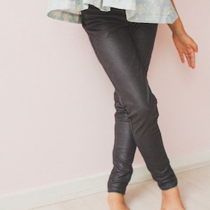 May include: A pair of black, shiny leggings. The leggings are fitted and have a slight sheen.