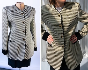May include: A white and black striped blazer with black trim and gold buttons. The blazer has a mandarin collar and a slightly fitted silhouette.