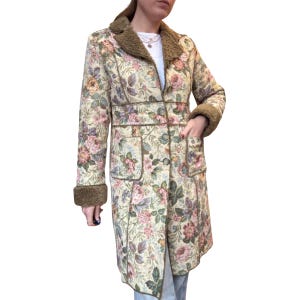 May include: A long floral coat with a cream background and a pattern of pink, purple, and yellow roses. The coat has a brown faux fur collar and cuffs, with two front pockets and a button closure. The coat is approximately 48 inches long.