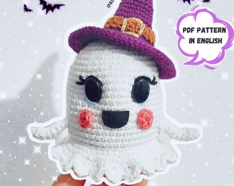 May include: Crocheted ghost wearing a purple witch hat with a brown buckle. The ghost has black eyes, a black smile, and pink cheeks. The image includes the text "PDF PATTERN IN ENGLISH".
