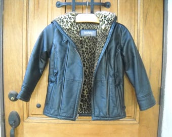 May include: Black leather jacket with a leopard print lining and hood. The jacket has a zipper closure, a hood, and a tailored fit. The jacket is hanging on a wooden hanger.