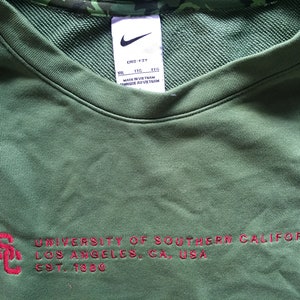 May include: Green sweatshirt with the text "UNIVERSITY OF SOUTHERN CALIFORNIA LOS ANGELES, CA, USA EST. 1880" in red.