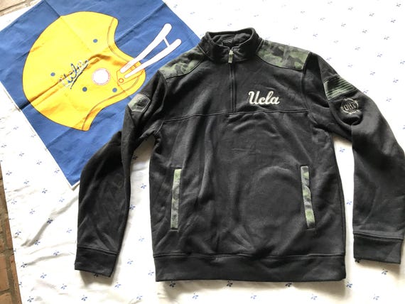 UCLA CAMO SWEATSHIRT Size Medium 70 Percent Cotton 30 Polyester 8 inch quarter zipper Soft Fleece inside 2 front pockets Patch/Emblem on arm