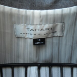 May include: A white label with the text "TAHARI ARTHUR S. LEVINE" and a smaller label with the text "16 VIETNAM" on a striped fabric background.
