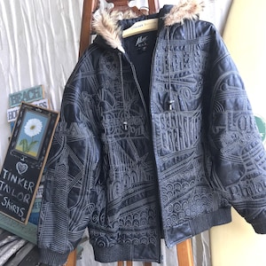 May include: Black leather jacket with intricate embossed designs, a fur-lined hood, and a zipper closure. The jacket features a ribbed hem and cuffs. The jacket has the text "Max USA" on the label.