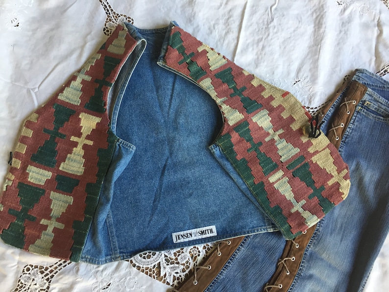 K&ouml;nnte beinhalten: Eine Jeansweste mit einem bunten, gemusterten Stoffbesatz. Die Weste hat ein Etikett mit der Aufschrift "Jensen Smith".