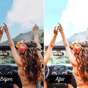 May include: Two people with their arms raised in the air, driving in a convertible with the top down. They are wearing floral headbands and are smiling. The car is driving through a mountainous landscape with a blue sky and white clouds in the background.