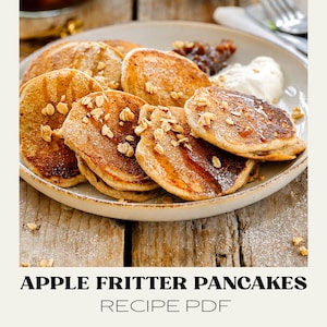 May include: A stack of golden-brown apple fritter pancakes on a round plate, topped with oats and syrup, accompanied by a dollop of cream. The text below reads APPLE FRITTER PANCAKES RECIPE PDF in black and gray lettering on a light background.