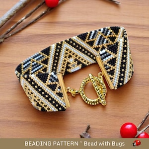 Peut inclure: Bracelet en perles noires, blanches et dorées avec un motif géométrique. Le bracelet a un fermoir doré.