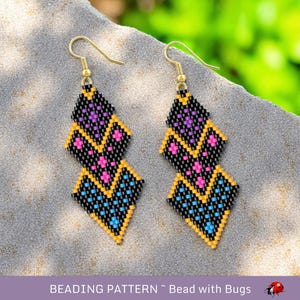 May include: A pair of beaded earrings with a geometric design. The earrings are black with yellow, pink, and blue accents. The earrings are hanging from gold hooks.