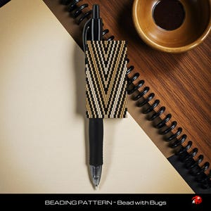 May include: A black pen with a beaded sleeve featuring a chevron pattern in black, tan, and cream colors. The pen rests on a notebook with a spiral binding, alongside a small wooden bowl. The text "BEADING PATTERN ~ Bead with Bugs" is at the bottom.