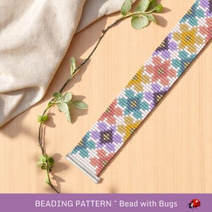 May include: A beaded watch band with a floral pattern in pastel colors, including pink, yellow, purple, and teal. The band is made of small beads and has a silver clasp. The text "BEADING PATTERN ~ Bead with Bugs" is at the bottom.