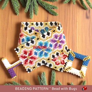 May include: A colorful beaded bracelet with a geometric pattern of flowers and squares. The bracelet is made with white, black, gold, blue, pink, and purple beads. The bracelet has a clasp made of blue and gold beads.