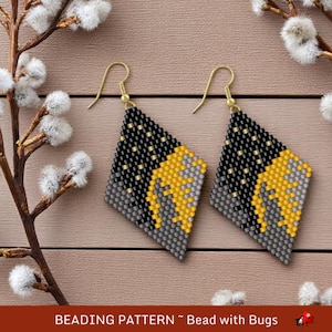 Può includere: Un paio di orecchini a forma di diamante con un motivo a perline. Gli orecchini sono neri, grigi e dorati con un design geometrico. Gli orecchini sono appesi a ganci dorati.