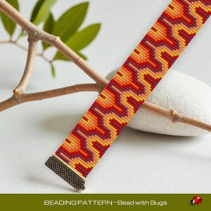 May include: A beaded bracelet with a geometric pattern in shades of red, orange, and yellow. The bracelet has a bronze-colored clasp. The text "BEADING PATTERN - Bead with Bugs" is at the bottom of the image.