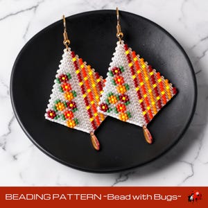 Puede incluir: Un par de pendientes de cuentas hechos a mano con forma triangular. Los pendientes presentan una base blanca con patrones coloridos de cuentas naranjas, amarillas y rojas. Se incorporan pequeños diseños florales. Los pendientes se exhiben en un plato negro. El texto "BEADING PATTERN ~Bead with Bugs~" está en la parte inferior.