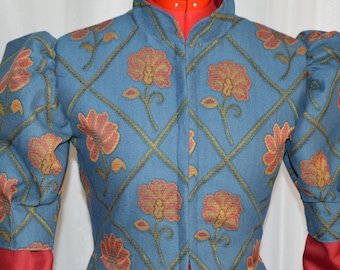 May include: A blue jacket with a floral pattern. The jacket has a high collar and puffed sleeves. The floral pattern is in shades of orange and gold, set against a diamond grid. The sleeves are gathered at the wrist, and the lining is red.